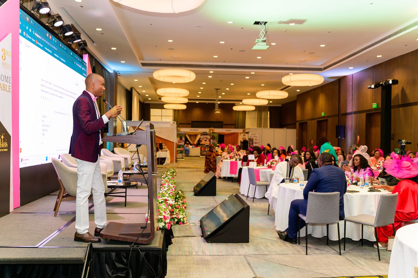 Cephas Gathii presenting on stage to a conference audience
