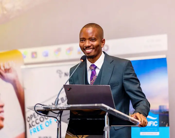 Cephas smiling at a podium while presenting